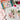 Floral painting kit with completed artwork, paintbrushes, and supplies on a light surface.