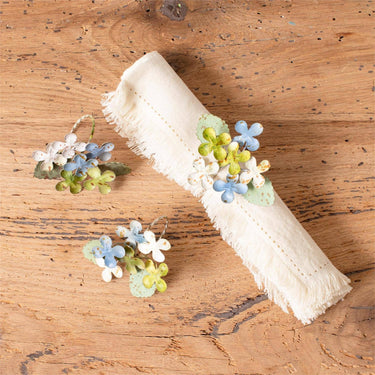 Audrey's Home & Gift - Dainty Metal Hydrangea Napkin Rings, one shown around a cloth napkin