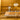 Dining room with a table set for a meal against a mustard yellow wall.