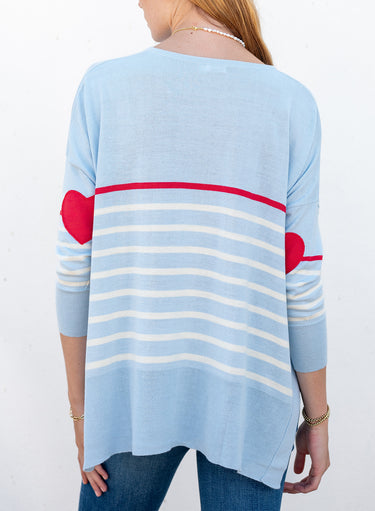 MERSEA’s Amour striped sweater with heart appliqué on elbow. Sweater is pale blue with narrow white stripes. The top stripe is Scarlet, and the heart appliqués are also Scarlet.