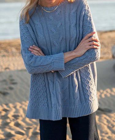 Mersea cable-knit Cotswold sweater in Misty Blue. One size, features a side-slit