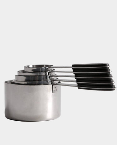 A set of nested stainless steel measuring cups with black handles, shown on a light gray background.