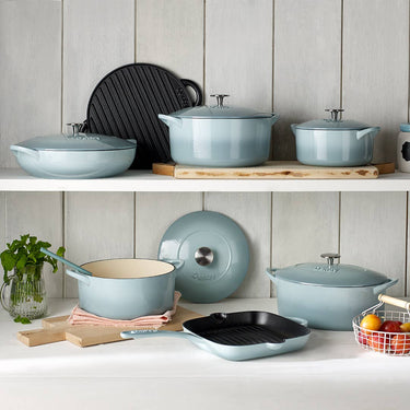 Set of light blue cookware on a kitchen shelf with a neutral background