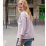 Woman wearing a striped shirt and jeans on a city street.