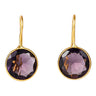 A pair of gold drop earrings with faceted oval purple gemstones in bezel settings, shown against a plain white background.