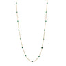 A delicate gold chain necklace featuring evenly spaced, small round green gemstone beads, displayed against a solid white background.