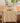 A table runner with a yellow lemon and green leaf pattern, styled on a wooden dining table with plates, cutlery, and a glass vase.