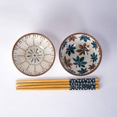 Two ceramic bowls with decorative patterns and a set of chopsticks on a white background